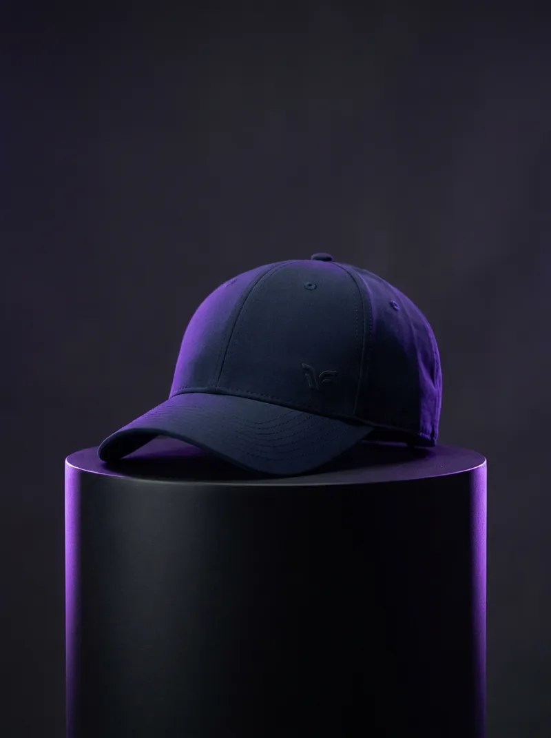 Streetwear product shot — navy performance cap under violet rim light